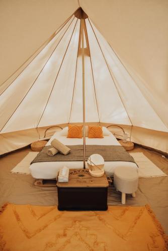ein großes Bett in einem Zelt mit einem Tisch in der Unterkunft Cocooning Tipi - Seignosse in Seignosse
