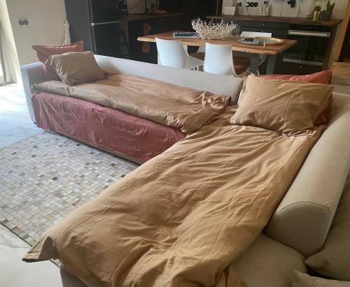 a couch with a blanket on it in a living room at Cozy beach house Jurmala in Jūrmala