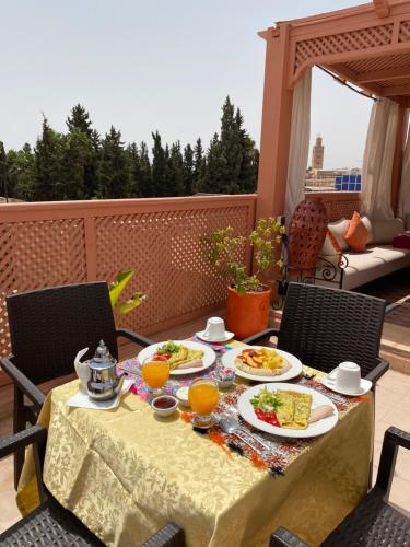 - une table avec des assiettes de nourriture sur une terrasse dans l'établissement Dar Asdika, à Marrakech