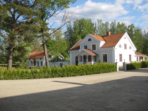 uma casa branca com um telhado vermelho em Bäcks Bed & Breakfast em Vintrosa