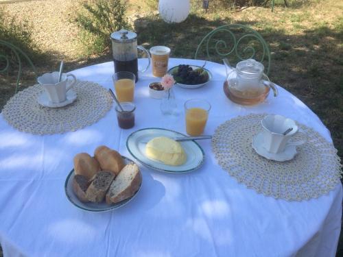 einen blauen Tisch mit Teller Brot und Tassen Kaffee in der Unterkunft Chambre hôtes Les Garrigues CUCURON in Cucuron