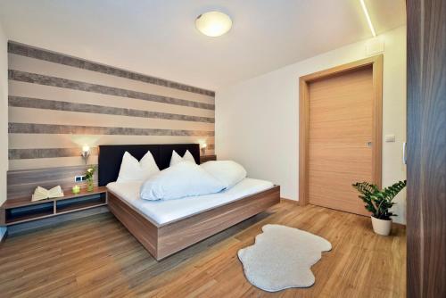 a bedroom with a bed with a striped wall at Alpenchalet Niederkofler Marilena in San Giovanni in Val Aurina