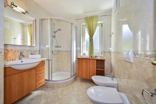 een badkamer met 2 wastafels, een douche en een toilet bij Alpenchalet Niederkofler Evita in San Giovanni in Val Aurina