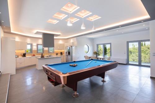 a pool table in a large room with a kitchen at Five Stars Villa in Kommeno