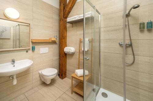 a bathroom with a shower and a toilet and a sink at Unesco Prague Apartments in Prague