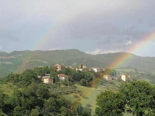 un arco iris sobre un pueblo con casas y árboles en CASA LINARA, en Frontino