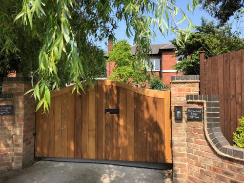 a wooden gate in front of a brick fence at Borrowfield Lodge in Derby