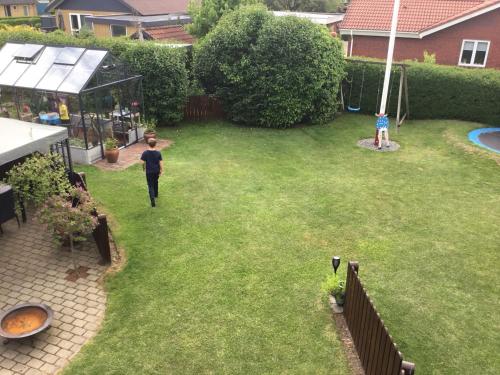 an aerial view of a backyard with a man standing in the grass at Glejbjerg Bed and Breakfast in Glejbjerg