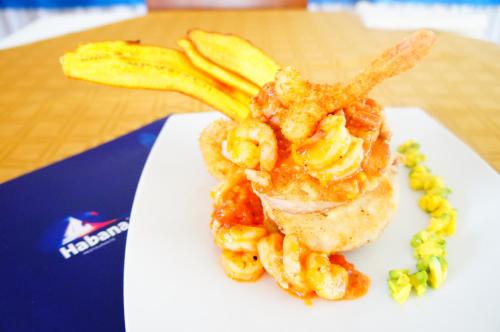 a plate of food with shrimp and fries on a table at Hotel Buena Vista Express in Bucaramanga
