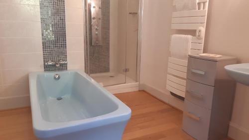 uma casa de banho branca com uma banheira e um lavatório em La Source du Mont em Saint-Martin-Valmeroux
