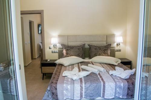 a bedroom with a bed with white towels on it at Glyfada Beach Hotel in Glyfada