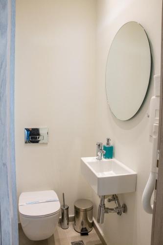 a bathroom with a toilet and a sink and a mirror at Glyfada Beach Hotel in Glyfada