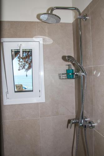 a bathroom with a shower with a window at Glyfada Beach Hotel in Glyfada