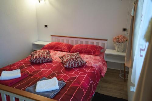 a bedroom with a red bed with two pillows at Casa Sofia in Borsa