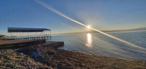 a dock on a body of water with the sun setting at Svir Skyline Apartment No 39 in Ohrid