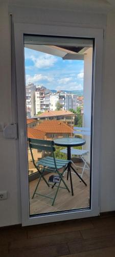 a glass door with a table and a view of a city at Svir Skyline Apartment No 39 in Ohrid