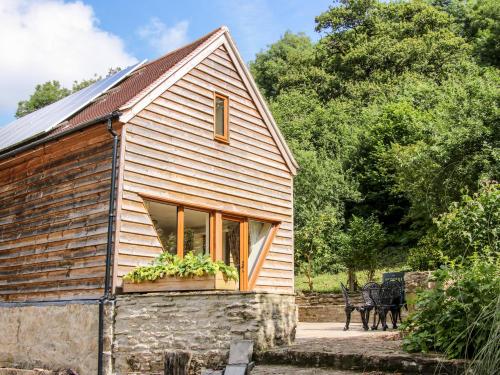 a house with a window and two horses standing outside at Pool Barn in Craven Arms