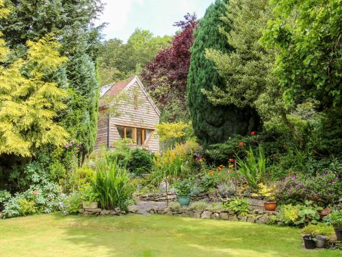 a garden in front of a house with flowers at Pool Barn in Craven Arms