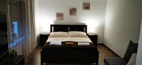ハイドゥソボスローにあるMeggyfa vendégházのベッドルーム1室(大型ベッド1台、ナイトスタンド2台付)