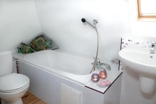 a bathroom with a tub and a toilet and a sink at Piastowska in Polanica-Zdrój