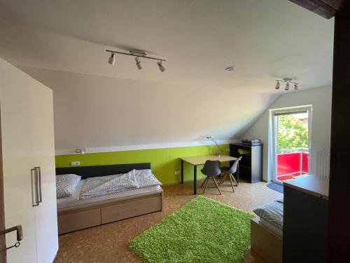 a room with a bed and a desk with a green wall at K14 - Oase im Grünen in Sankt Florian bei Linz