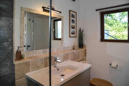 uma casa de banho com um lavatório e um espelho em Luxury countryside cottage with mountain views em Roquefixade