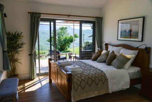 1 dormitorio con 1 cama y puerta corredera de cristal en Luxury countryside cottage with mountain views en Roquefixade