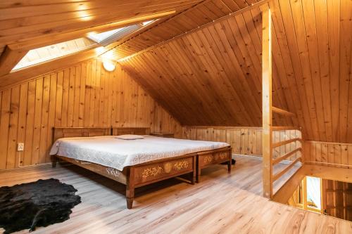 a bedroom with a bed in a wooden cabin at Pokoje u Gronicki in Bukowina Tatrzańska