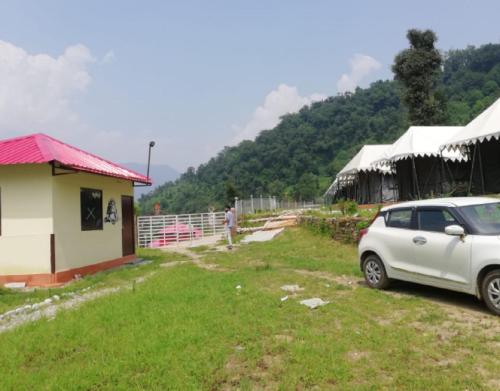 a white car parked in front of a building at Kedarnath Eco Retreat by StayApart in Barmoāri