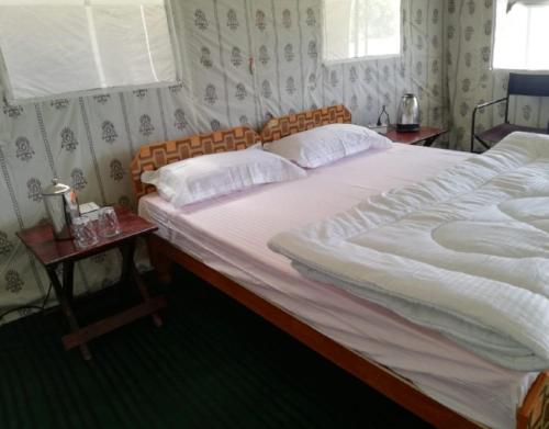 a bedroom with a large bed and two night stands at Kedarnath Eco Retreat by StayApart in Barmoāri