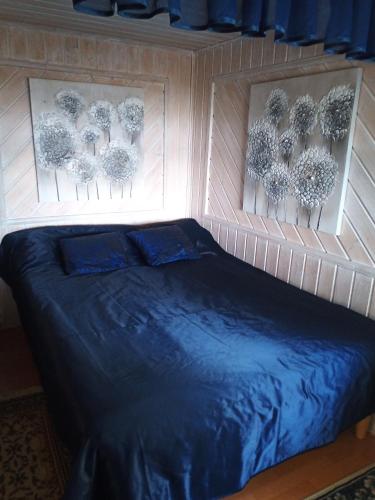 ein Bett in einem Zimmer mit zwei Bildern an der Wand in der Unterkunft Verlan Satumaa in Verla