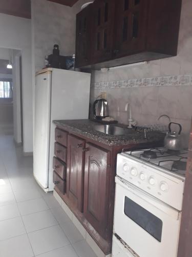 a kitchen with a stove and a white refrigerator at Hermosa Casita II Paso Patria in Paso de la Patria