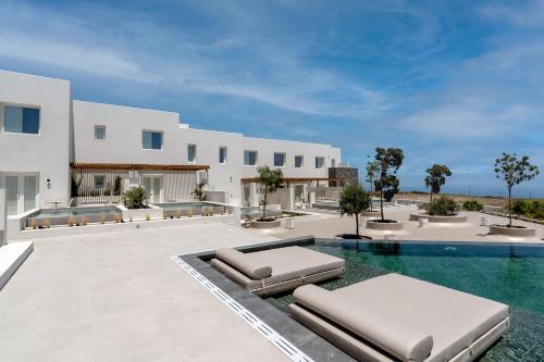 an outdoor swimming pool with two chaise lounges at Lilium Homes in Karterados