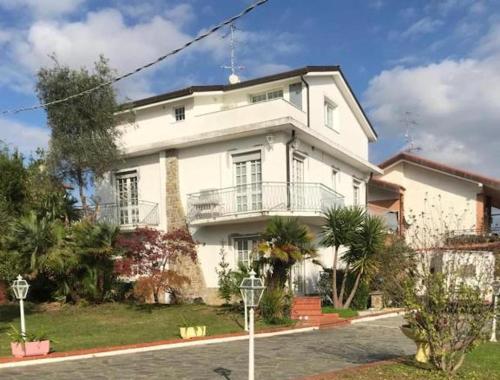 una gran casa blanca con una entrada delante de ella en VILLA FELICE en Loano