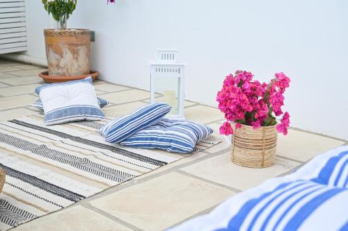 a table with blue and white pillows and a vase of flowers at Pietro Maggi - Apulian Historical House in Manduria