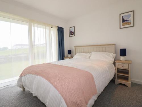 a bedroom with a large bed and a window at 7 Europa Court in Newquay