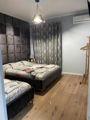 1 dormitorio con 2 camas y luz colgante en Guest House Kondili, en Përmet