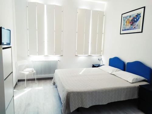 Schlafzimmer mit einem Bett, einem Stuhl und Fenstern in der Unterkunft IL DUOMO in Cesena