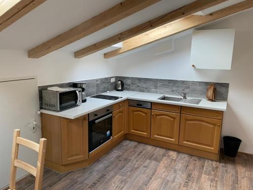 a kitchen with wooden cabinets and a microwave at Haus Izabella in Filzmoos