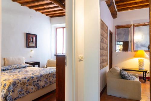 ポルトフェッラーイオにあるAppartamenti Un Amoreのベッドルーム1室(ベッド1台、ソファ、椅子付)
