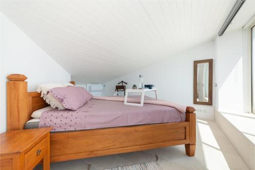 Un dormitorio con una cama con marco de cama de madera. en Casa REWA, en Puerto de Alcudia