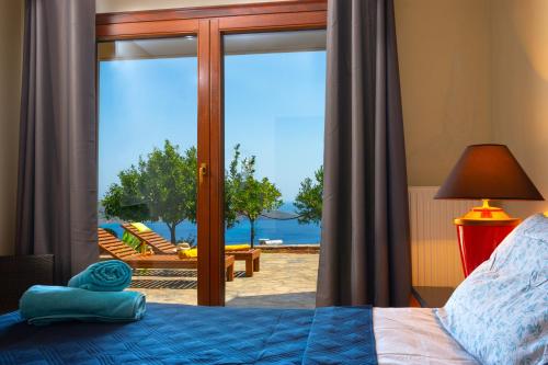 a bedroom with a bed and a view of the ocean at Athina Stunning Elounda View Apartment in Elounda