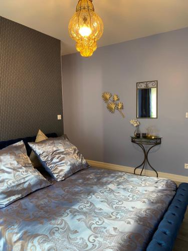 a bedroom with a bed and a chandelier at The Splendid View - 8 Personnes in Bouillon