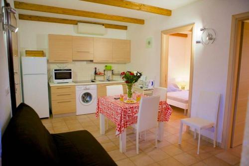 une cuisine avec une table et des chaises et une cuisine avec un évier dans l'établissement Locations l'Inzecca, à Ghisonaccia