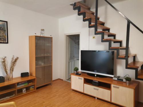 a living room with a television and a staircase at Edina-ház in Balatonboglár