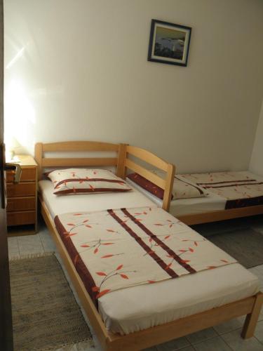 two twin beds in a room with at Apartments Babić in Novalja