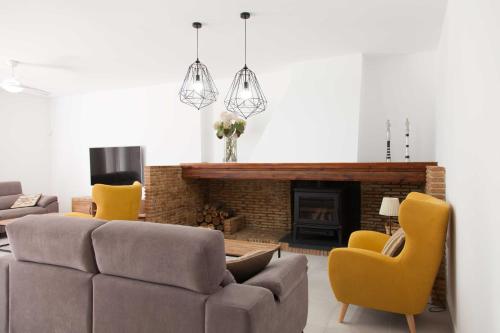 a living room with a couch and chairs and a fireplace at Villa Conchin Casa junto a Parque Natural in Alberique
