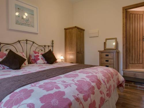 a bedroom with a bed and a dresser and a television at Jenny Wren in Holsworthy