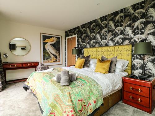 - une chambre avec un lit et un mur orné d'une fresque ornée d'oiseaux dans l'établissement Sennen Skies, à Penzance