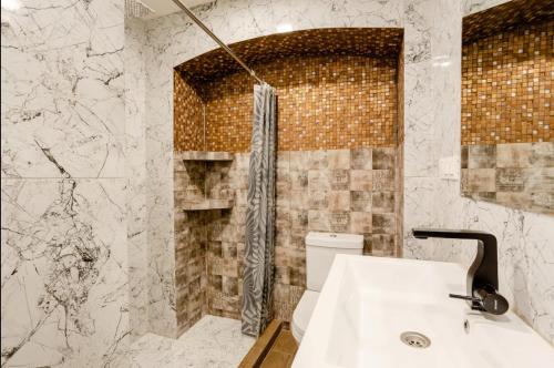y baño con lavabo blanco y ducha. en lovely Dulcet Loft In Center Of Rustaveli, en Tiflis